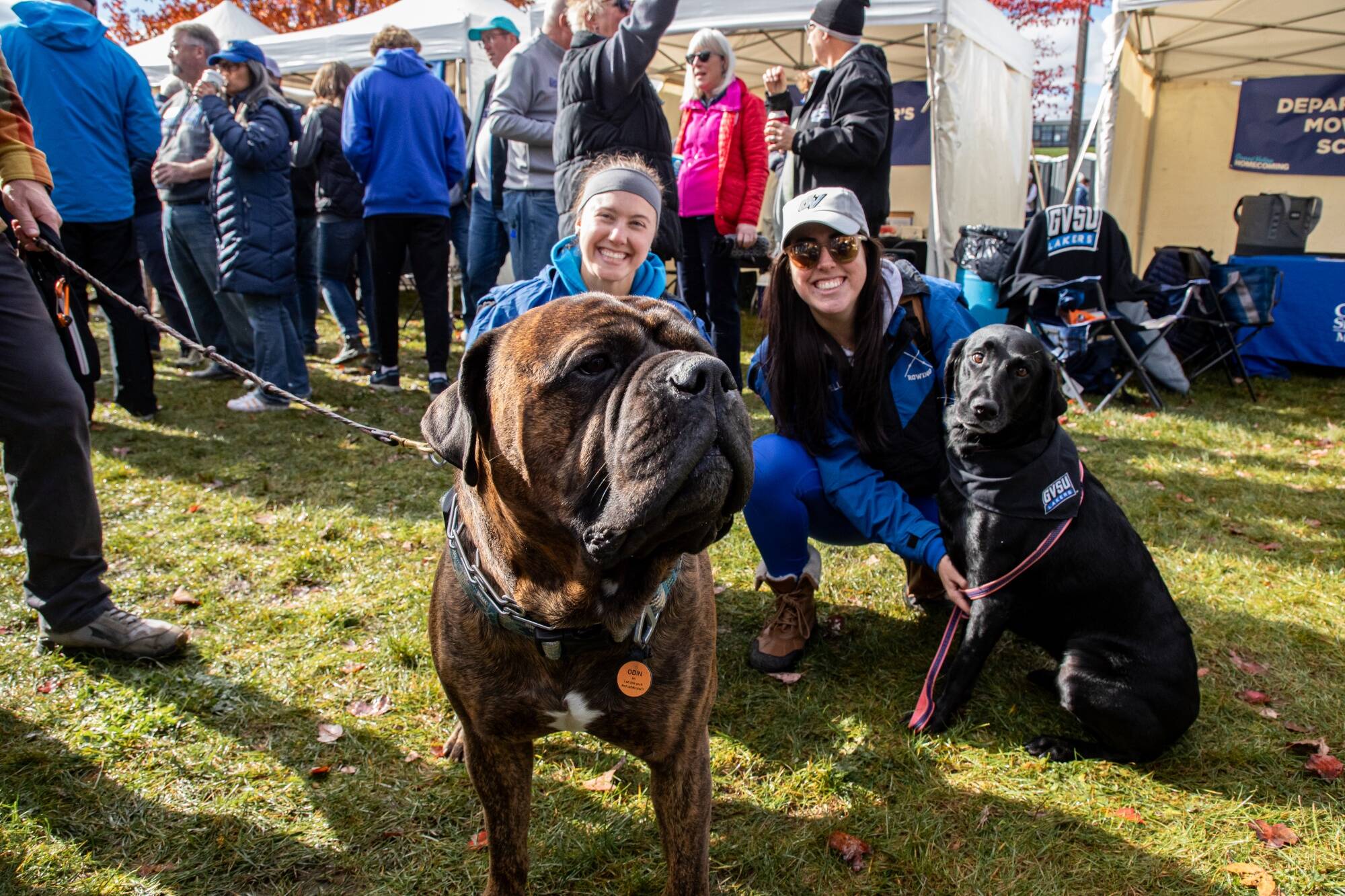 Alumni smile at Homecoming with their dogs